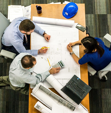 Two men and one woman in a business planning meeting